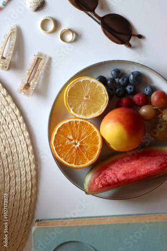 Obraz na płótnie Glass of cocktail, straw hat, sunglasses, books, fresh fruit, chocolate and accessories. Summer essentials on the table. Top view. w salonie