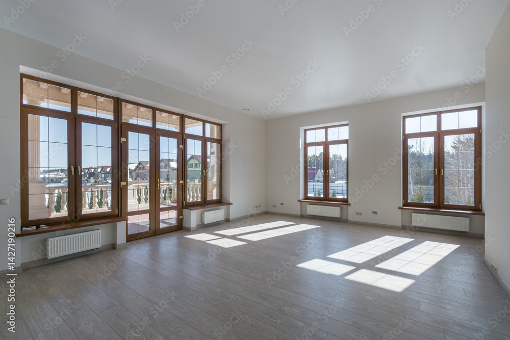 Obraz premium An empty room with the final finish in a luxurious mansion. Panoramic window with double doors and access to the balcony.