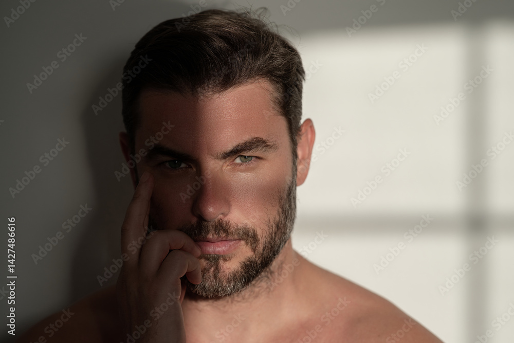 Sexy shirtless man close up portrait care of skin, isolated over white background. Charming man with perfect smooth soft skin. Spa therapy. Man, face, beauty and skincare concept.