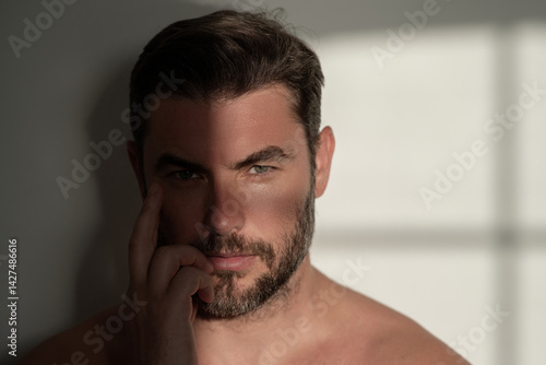 Obraz na płótnie Sexy shirtless man close up portrait care of skin, isolated over white background. Charming man with perfect smooth soft skin. Spa therapy. Man, face, beauty and skincare concept. w salonie