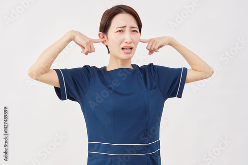 女性　美容看護師　耳を塞ぐ　白背景
