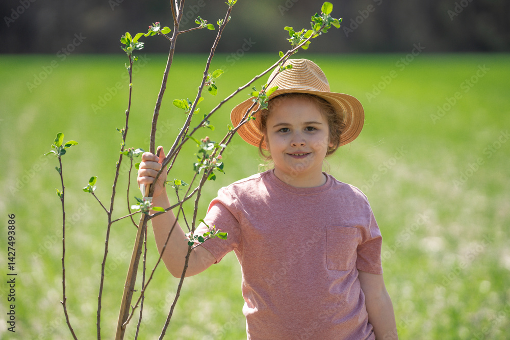 Child planting tree in spring field. Planting with watering can and shovel. Child cultivating tree on garden farm. Child work.