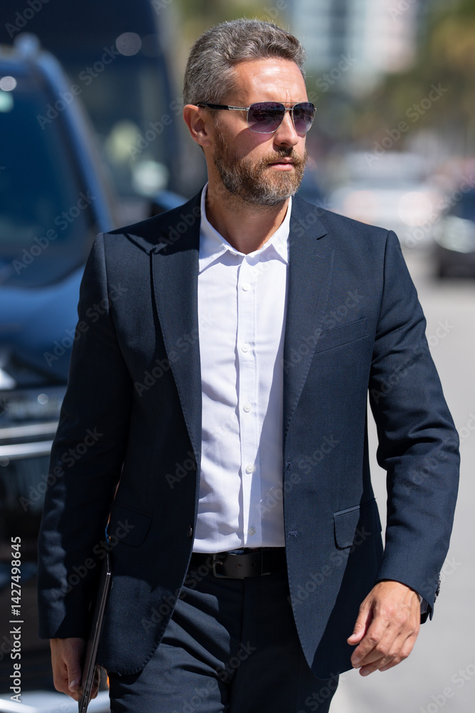 Business man in suit outdoors. Rich businessman next to a luxury car. Global business. Successful business. Elegant business man in front of expensive car. Successful businessman.