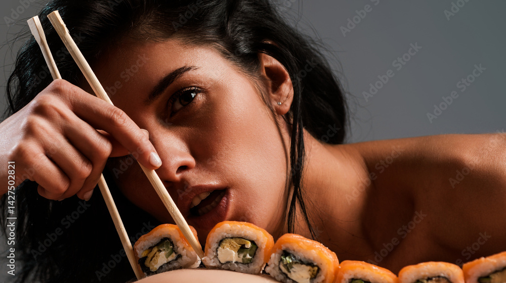 Sushi closeup in sexy woman mouth. Sexy woman eating sushi with chopsticks. Model eat sashimi. Sensual bite of sushi. Female tasting nigiri. Lunch at Japanese restaurant. Desire for delicious sushi.