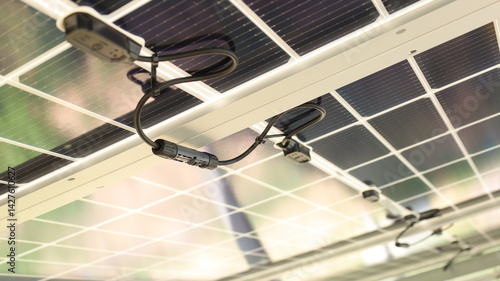 Solar cell connector. Close-up of Solar PV connector of solar cell circuit and wires under solar panel in smart farm with copy space and focus selection.