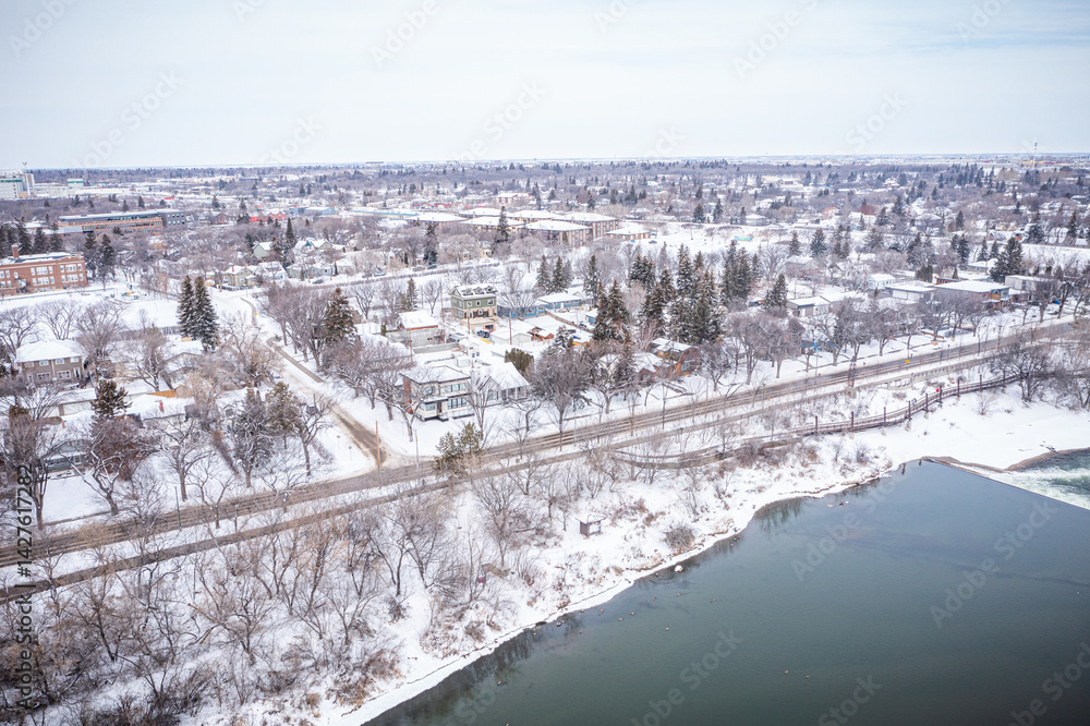 Obraz premium Snowy city with a river running through it