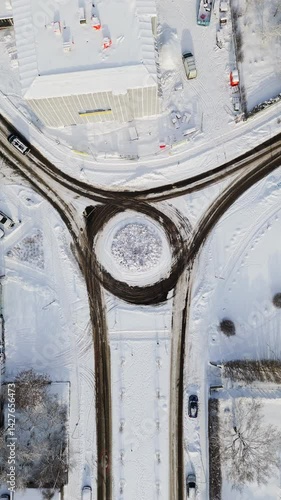 Wallpaper Mural Vertical drone shot above traffic in a snowy city roundabout, sunny, winter day Torontodigital.ca