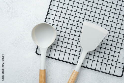 Modern kitchen utensils arranged on a cooling rack in a minimalist style
