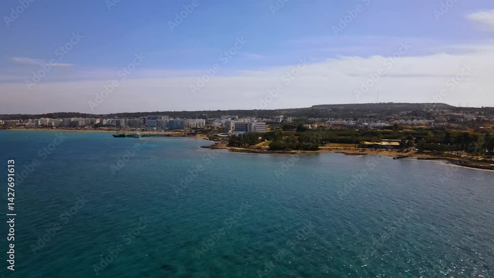 Summer days in Protaras, Cyprus. The camera flies over the turquoise Mediterranean Sea and the beach line surrounded by hotels. Summer days in Protaras, Cyprus. The camera flies over the turquoise Mediterranean Sea and the beach line surrounded by hotels.