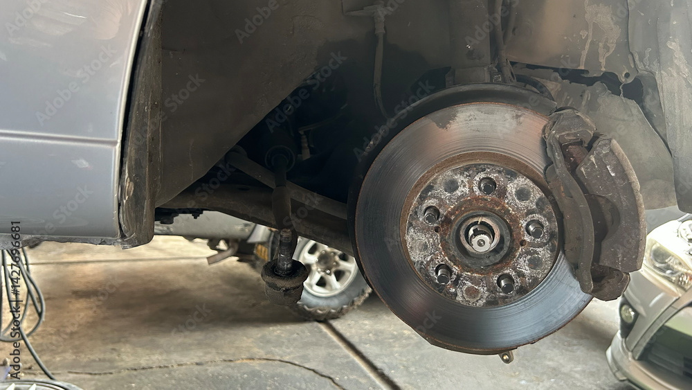 Close-up of a car disc brake during maintenance in a garage workshop, showcasing automotive repair and service. Close-up of a car disc brake during maintenance in a garage workshop, showcasing automotive repair and service.