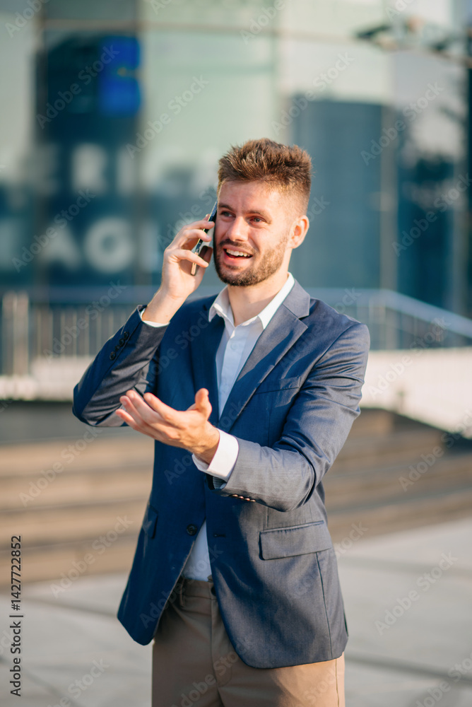 businessman works outdoors near the office holds a tablet, smiles reads good news businessman works outdoors near the office holds a tablet, smiles reads good news