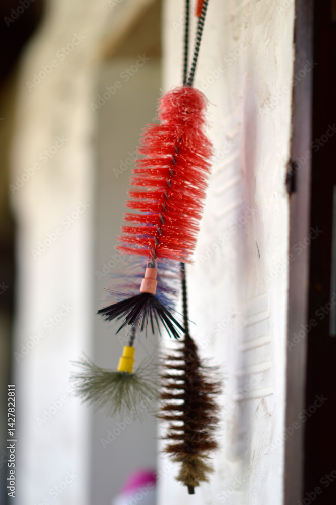 old brushes for cleaning glass bottles hanging on the wall