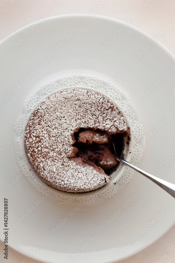 Fototapeta premium Looking down on chocolate soufflé broken with spoon