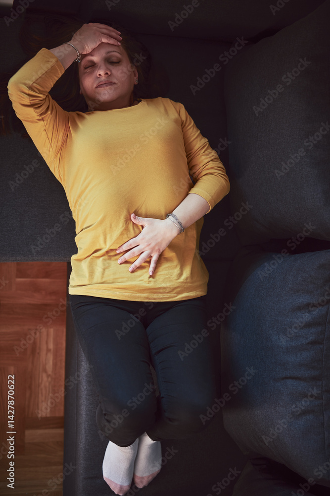 Woman with strong stomach ache, menstrual and digestive issues at home.
