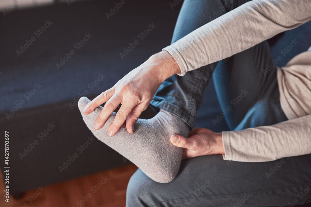Man with ankle and foot pain at home.