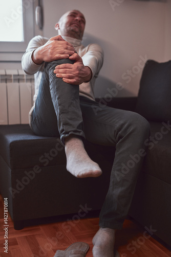 Obraz na płótnie Man with painful knee and leg injury at home. w salonie