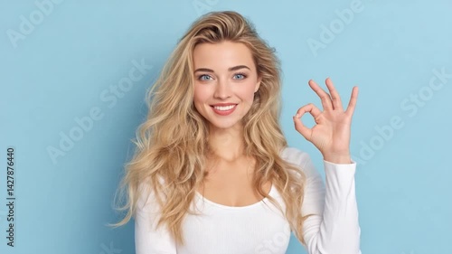 Wallpaper Mural OK Sign: A radiant woman, with flowing golden locks and a captivating smile, confidently displays the universal "OK" hand gesture against a refreshing backdrop. Torontodigital.ca