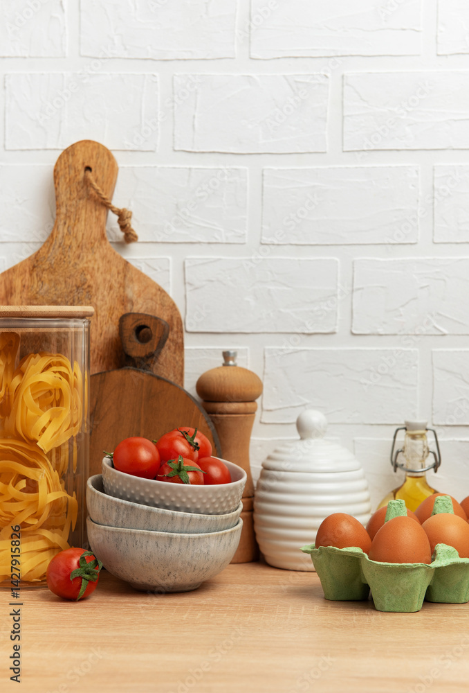 Italian food, cherry tomatoes, pasta, eggs and olive oil creating cozy kitchen scene