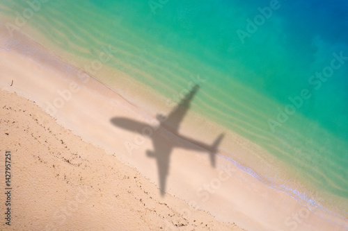 Aerial view of shadow passenger plane silhouette and sandy beach blue sea with waves at sea beach summer vacation sea travel concep