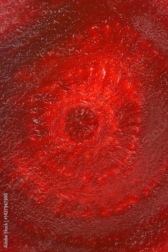A close-up shot reveals the deep red and textured surface of a sliced beetroot, showcasing its concentric rings