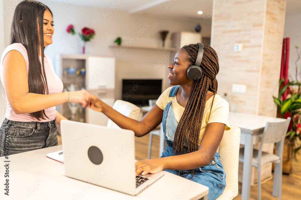 Happy students shaking hands while studying at home