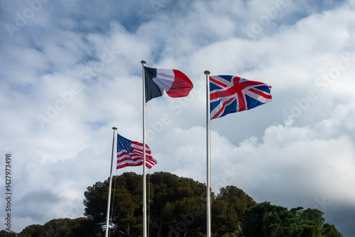 les drapeaux de la France, du Royaume-Uni et des Etats-Unis sont accrochés cote à cote et flottent dans le ciel