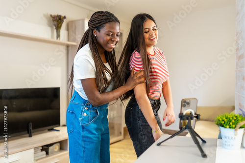 Teenage girls creating content with smartphone at home