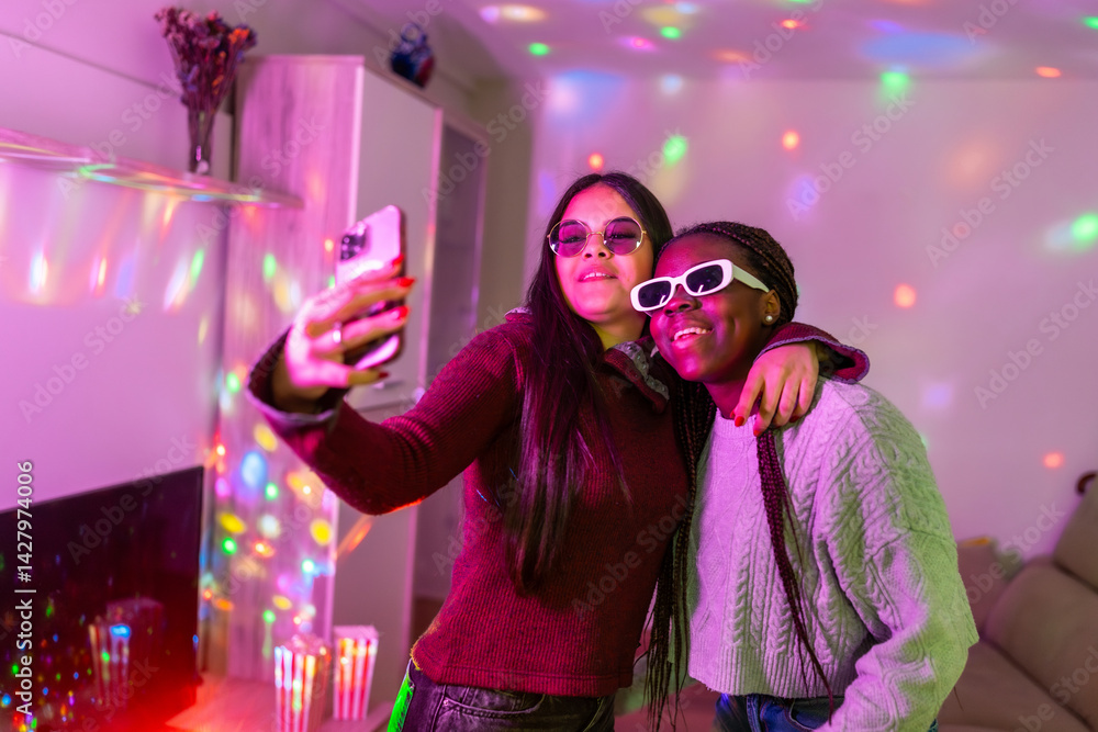 Teenage girls taking selfie with smartphone at home party