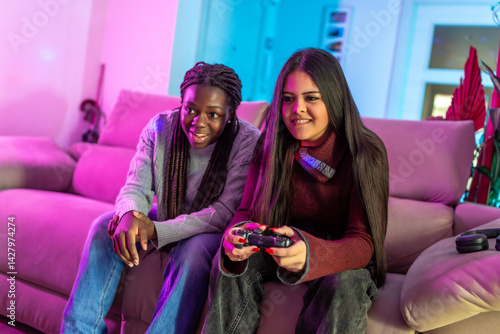 Obraz na płótnie Teenage girls playing videogames at home on sofa w salonie