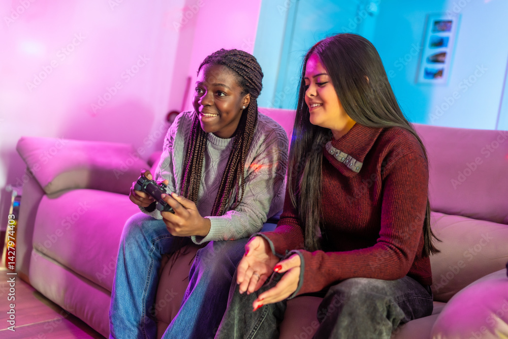 Two female teenagers playing videogames at home