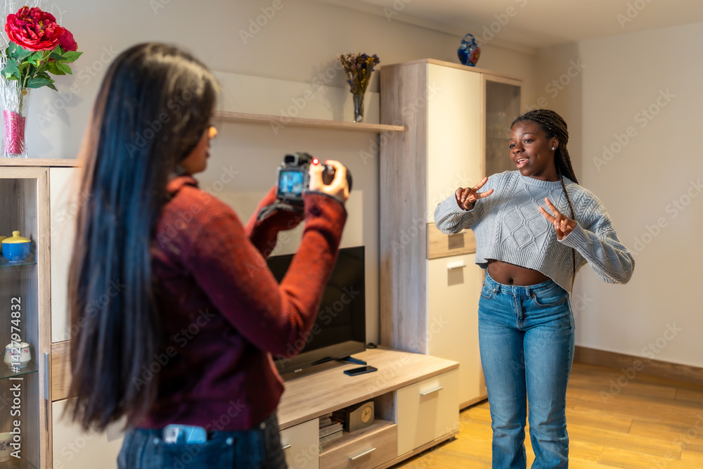 Teenage girls filming dance video at home with photo camera
