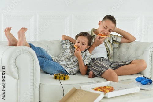 Obraz na płótnie Kids Eating Pizza on the Couch w salonie