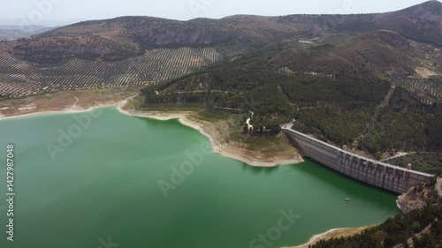 Panoramic aerial view of Iznajar Reservoir. The largest reservoir in Andalusia and the second largest in Spain in terms of extension. Beautiful travel destination. Drone panning left. 