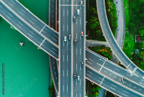 Aerial of vehicles navigate a complex highway system, showcasing overpasses and intersections.