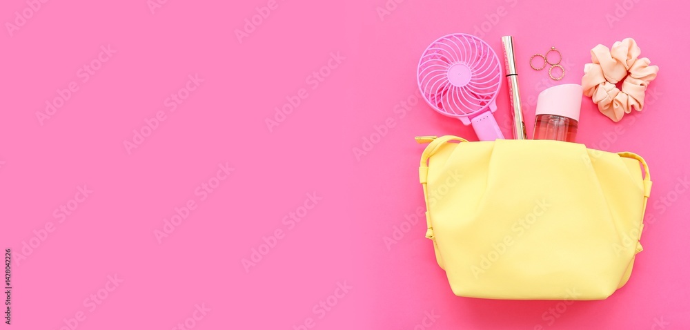 Cosmetic bag with portable electric fan and female accessories on pink background with space for text