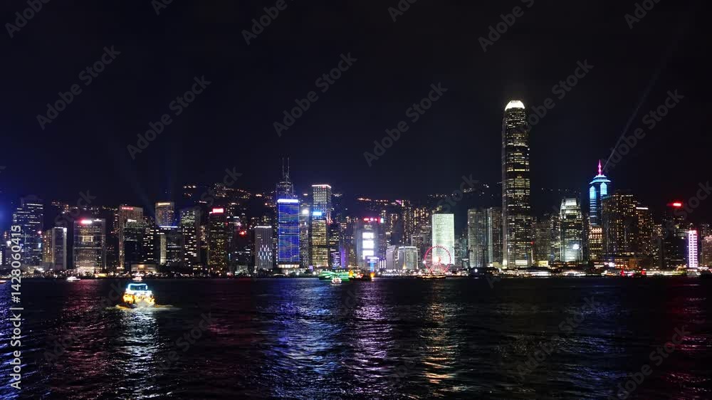 Stunning panoramic view of Hong Kong's skyline at night, showcasing illuminated skyscrapers and a beautiful evening light show. Vibrant colors reflect on the water as boats glide by Stunning panoramic view of Hong Kong's skyline at night, showcasing illuminated skyscrapers and a beautiful evening light show. Vibrant colors reflect on the water as boats glide by