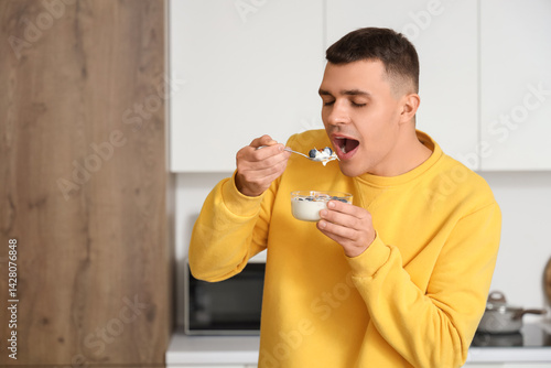 Young man eating tasty yogu...