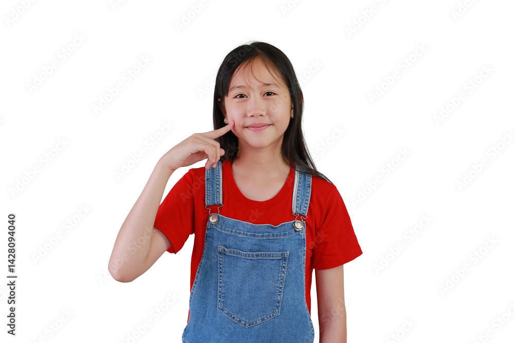 Portrait smiling Asian girl child keeping fingers on cheek. Kid standing and looking straight at camera isolated on white studio background.