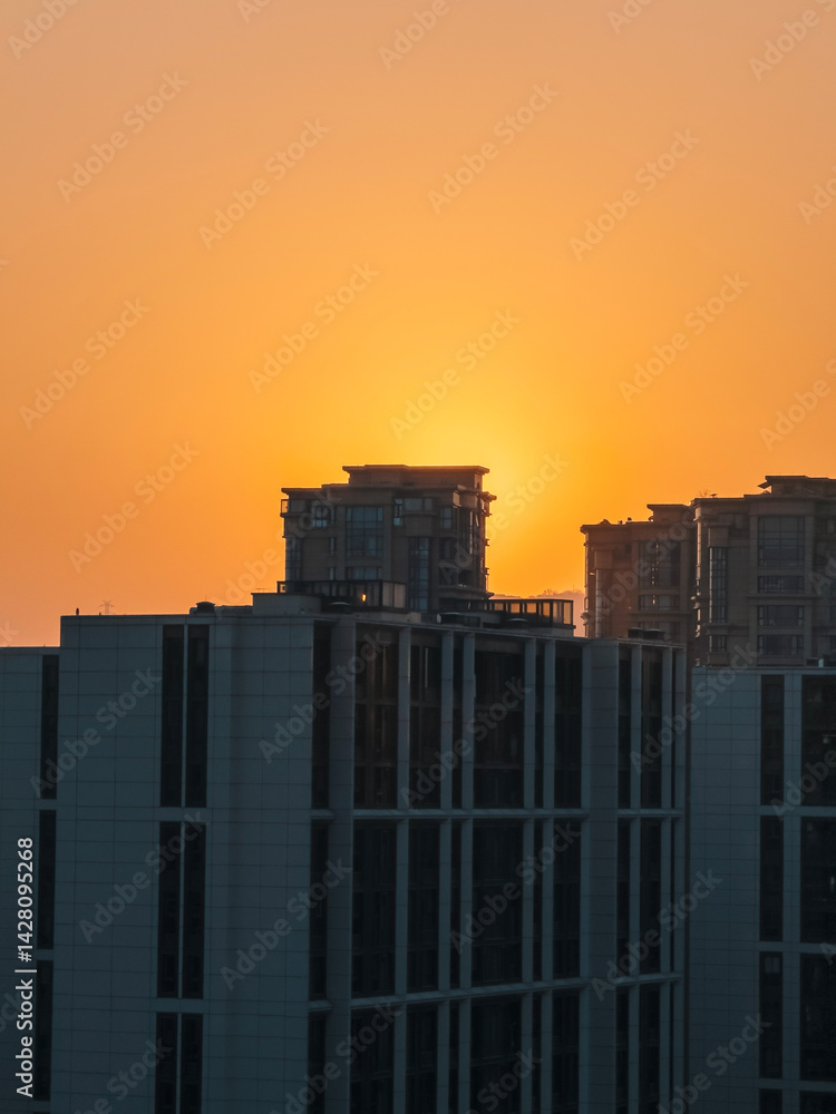 Sunrise casting warm light over modern buildings in an urban landscape Sunrise casting warm light over modern buildings in an urban landscape