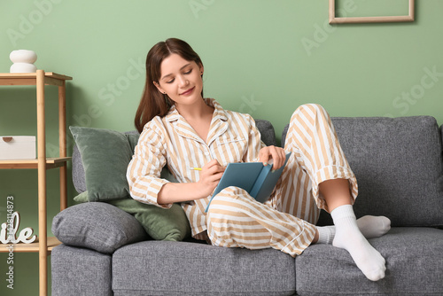 Young woman in pajamas writ...