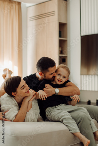 Happy family embracing and cuddling on sofa in living room