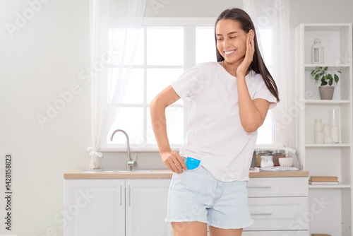 Young woman putting condom ...