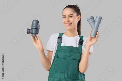 Female plumber with pipes o...
