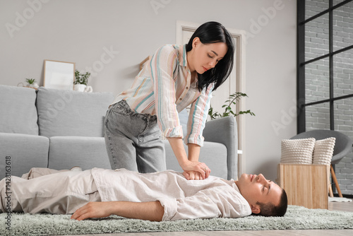 Young woman doing CPR on un...