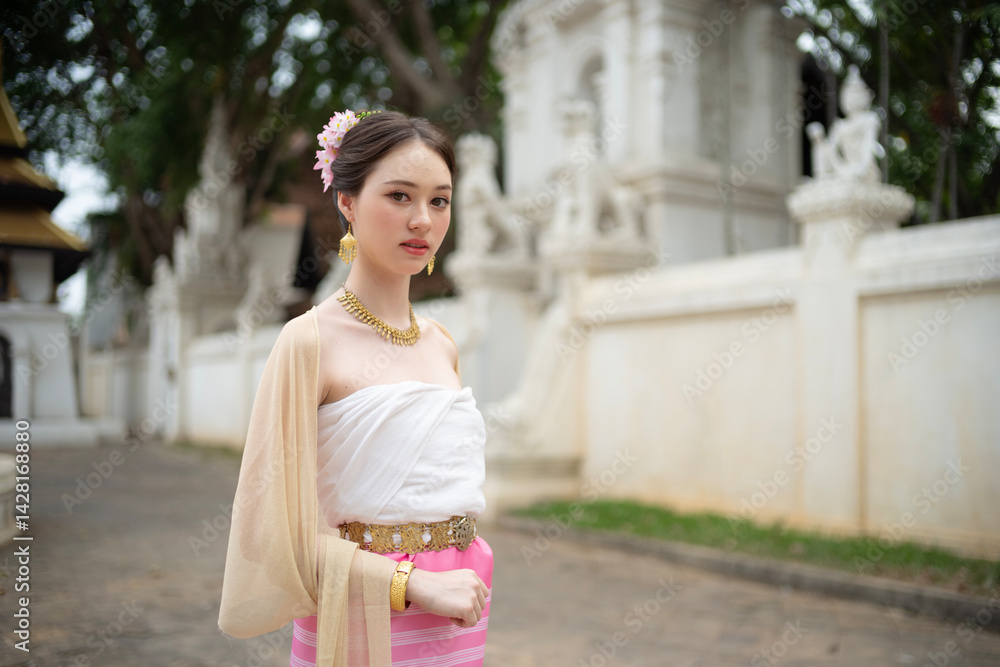 Beautiful young Asean woman in traditional Thai Dvaravati dress in an old temple in Chiang Mai, Thailand.