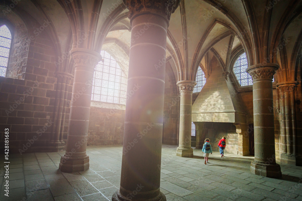 Children explore historic stone hall with grand arches