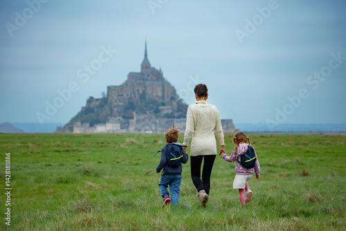Mother with kids walk toward a historic castle on cloudy day