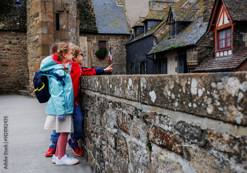 Obraz na płótnie Two children with backpacks explore a rustic stone building w salonie