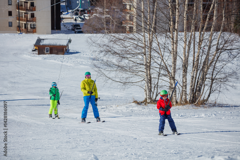 Group of skiers on tow lift enjoy snow slope at sunny winter day