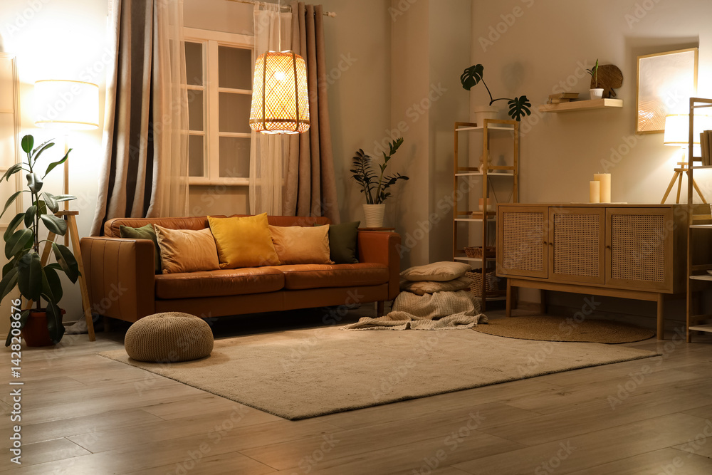 Interior of stylish living room with brown sofa, houseplants and glowing lamps at evening